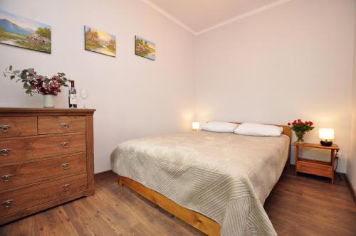 een slaapkamer met een bed en een dressoir met 2 kussens bij Słoneczny Apartament przy Rynku in Wrocław