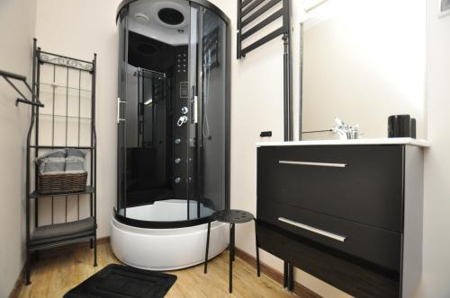 een badkamer met een zwart-witte douche en een wastafel bij Słoneczny Apartament przy Rynku in Wrocław