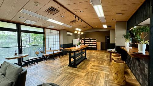 a large room with tables and chairs and windows at Yufuin Akarinoyado in Yufuin