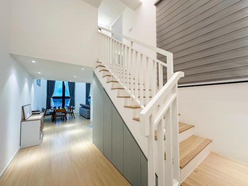 a staircase in a house with white walls and wooden floors at Sunway Grid Loft Suite by Nest Home【Olympic Size Pool】 in Kampong Pendas