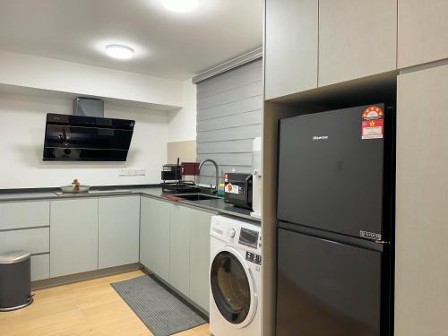 a kitchen with a dishwasher and a washer at Sunway Grid Loft Suite by Nest Home【Olympic Size Pool】 in Kampong Pendas