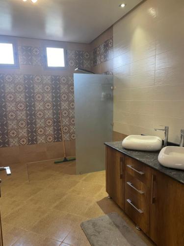uma casa de banho com 2 lavatórios e um espelho em Charmante villa avec piscine DAR LUD em Chichaoua