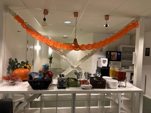 a table with food on it with an orange decoration at Pronova Hotell & Vandrarhem in Norrköping
