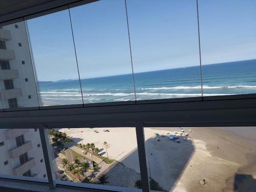 uma vista para a praia a partir de um edifício de escritórios em Apartamento Frente Mar 2 dormitórios em Solemar