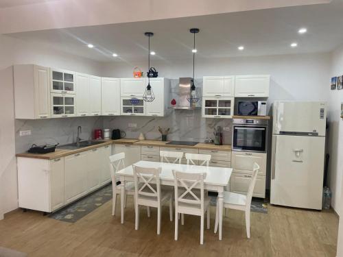 a kitchen with white cabinets and a table and chairs at Casa La Fenice Favignana in Favignana