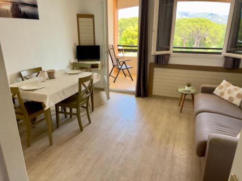 sala de estar con mesa y sofá en Appartement 4 Personnes dans Résidence Golf de Valescure 2, en Saint-Raphaël