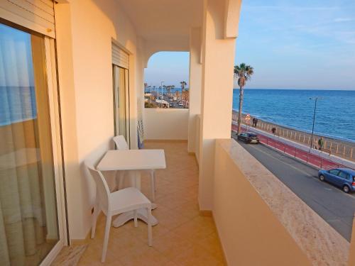 balcón con mesa y vistas al océano en Hotel Kaly, en Ventimiglia