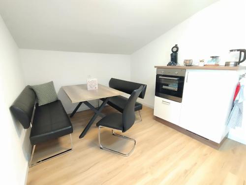 a small kitchen with a table and chairs and a counter at Carina's Apartment in Obsteig