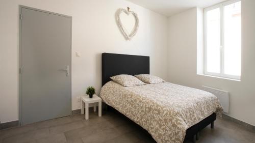 - une chambre blanche avec un lit et un miroir dans l'établissement Apparemment t3 au cœur champenois, à Charly-sur-Marne