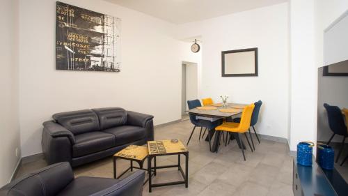a living room with a couch and a table and chairs at Apparemment t3 au cœur champenois in Charly-sur-Marne