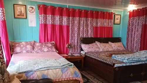 een slaapkamer met 2 bedden en rode gordijnen bij Lebong Mansara Homestay in Darjeeling
