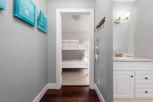 un bagno bianco con lavandino e specchio di Green Lake Central Cottage a Interlochen