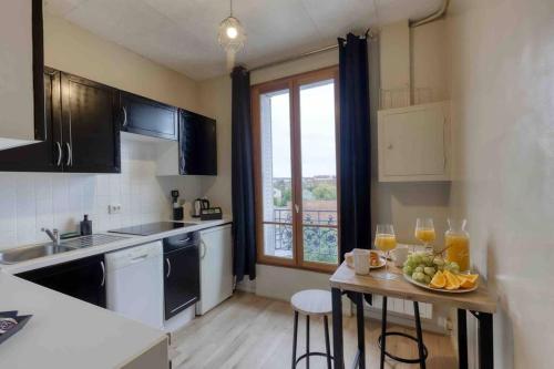 - une cuisine avec une table et une assiette de fruits dans l'établissement Le Doesburg - studio entre Paris & Fontainebleau, à Corbeil-Essonnes