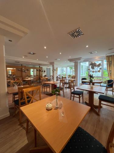 a dining room with wooden tables and chairs at Hotel Am Schlosspark , Wiesbaden in Wiesbaden