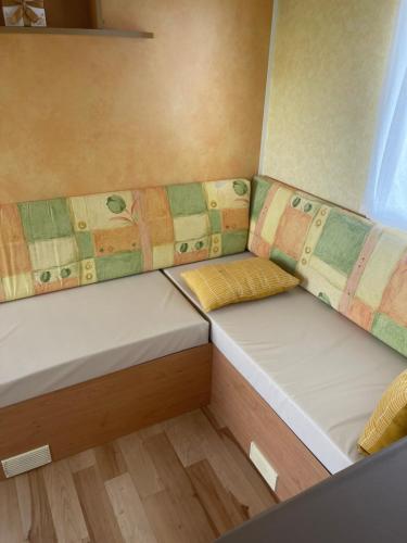 Cette petite chambre comprend 2 lits. dans l'établissement Mobil home 2 chambres tout confort avec terrasse, à La Chapelle-sur-Loire