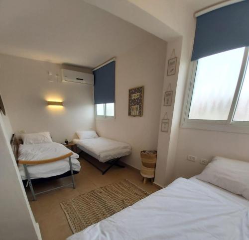 a room with two beds and a window at צימר - על פלגי מים in Menaẖemya