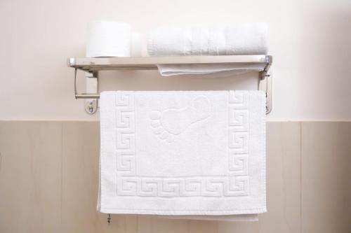 a towel rack with white towels in a bathroom at צימר - על פלגי מים in Menaẖemya