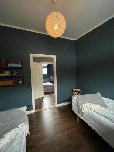 een slaapkamer met 2 bedden en een blauwe muur bij West Hult-the forrest house. in Virserum