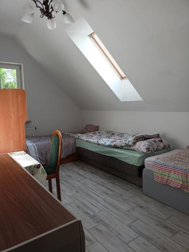 een kamer met 2 bedden, een bank en een raam bij U Stasia in Uścimów