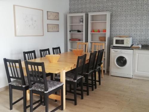 a dining room table with chairs and a microwave at Vivienda Vacacional El Robledo in Colombres