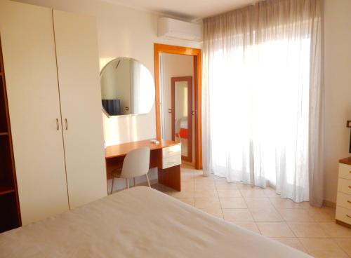 a bedroom with a dressing table and a mirror at Hotel Kaly in Ventimiglia