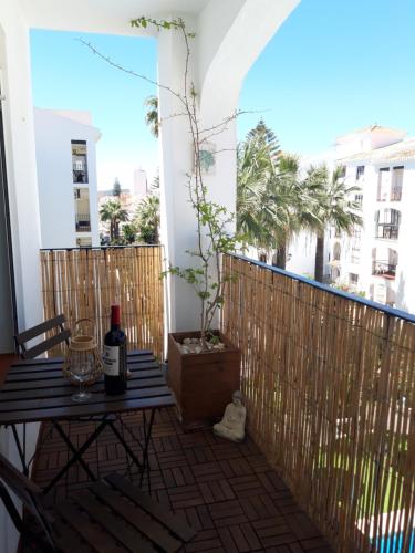 een balkon met een tafel en een fles wijn bij Sun & Sea Beach Apartment Sabinillas in San Luis de Sabinillas