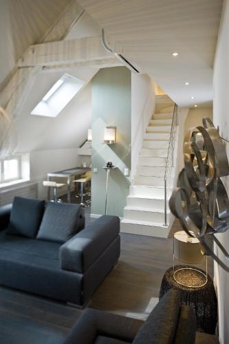 a living room with a blue couch and stairs at Maison d'Hôte de Myon in Nancy