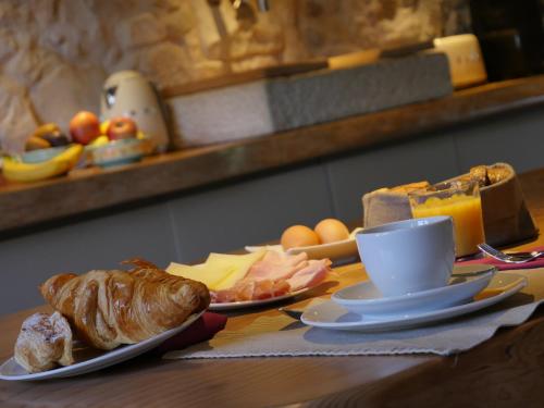 a table with two plates of bread and a cup of coffee at Villa San Liberale - Suites & Wellness - Villa Veneta in Feltre