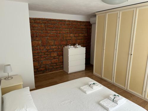 een slaapkamer met een bed en een bakstenen muur bij Casa Sole in Costermano