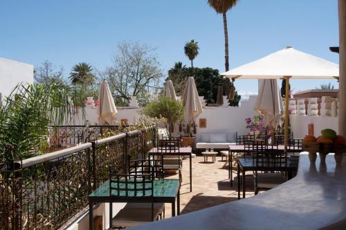 a patio with tables and chairs and umbrellas at Riad Sashema in Marrakesh