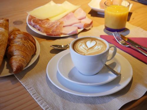 a cup of coffee and croissants on a table at Villa San Liberale - Suites & Wellness - Villa Veneta in Feltre