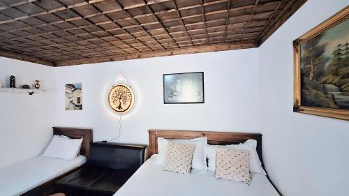 1 dormitorio con 2 camas y una foto en la pared en Guesthouse Alvaro Kadiu, en Berat