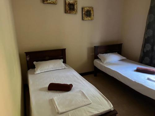 two beds in a small room with at Kalan Digana (Kandy) in Digana