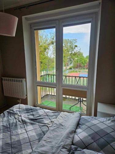 een slaapkamer met een bed en een groot raam bij Apartament kamienica in Gdynia