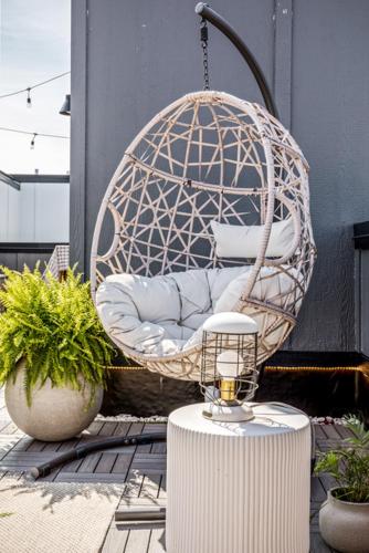 a swing chair on a patio with two plants at The Loft on Gillis AC Downtown Beach Rooftop in Traverse City