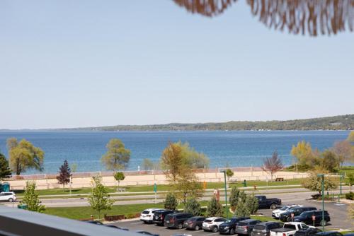 a parking lot with cars parked next to a body of water at The Loft on Gillis AC Downtown Beach Rooftop in Traverse City