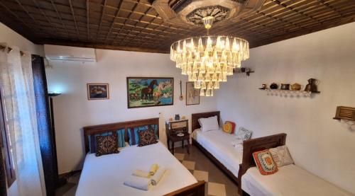 Habitación con 2 camas y lámpara de araña. en Guesthouse Alvaro Kadiu, en Berat