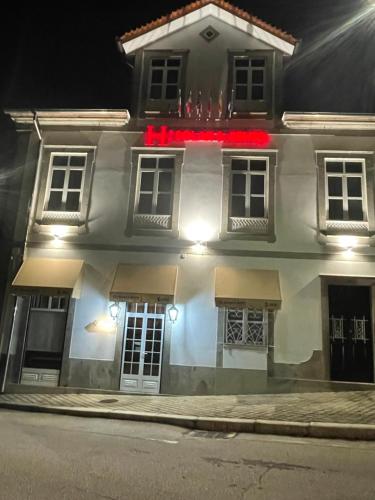 a white house with red lights on the front of it at Solar S.Bento in Santo Tirso