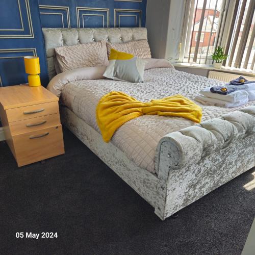 a bedroom with a bed with a yellow blanket on it at Aldwych house, For Holidays, Contractors & Relocation, Free Parking & Wi-Fi in Preston