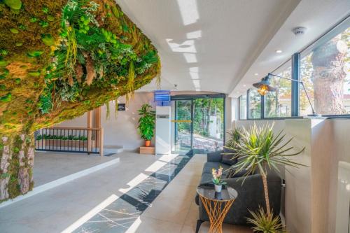 an office lobby with plants and a couch at MAGİA HOTEL in Istanbul