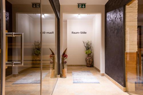 a hallway with a room with plants on the wall at Grandhotel Lienz Business-Wellness & Gourmet in Lienz