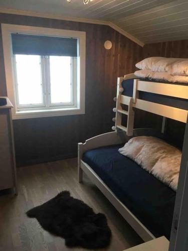 a bedroom with a bunk bed and a window at Hytte med god standard in Stranda