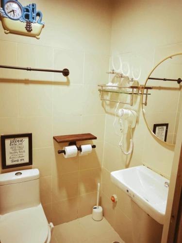 a bathroom with a toilet and a sink and a mirror at The ICONIC: Comfortable living by Awsom Phil in Manila