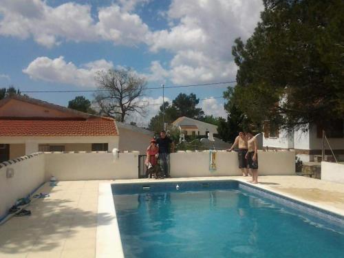 un groupe de personnes debout à côté d'une piscine dans l'établissement Casa Refugio Entre Pinos y Romeros, à Mogente