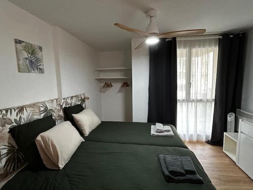 une chambre avec un lit vert et une fenêtre dans l'établissement Victoria Surf studio d'exception, à Biarritz