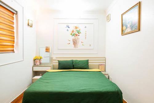 sypialnia z łóżkiem z zielonym kocem w obiekcie Old Quarter Hanoi Autumn House 8 w mieście Hanoi