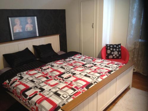 a bedroom with a bed and a red chair at Stop at The Cross in Borås