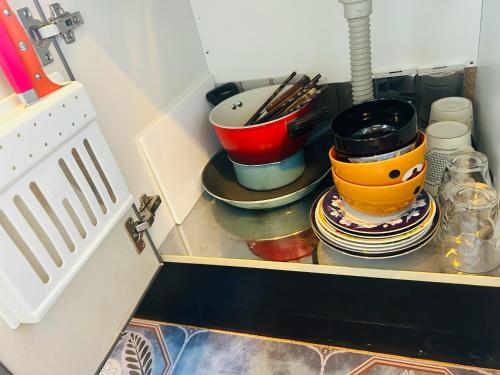 a kitchen counter with pots and pans on a shelf at Ueno Iriya hostel in Tokyo