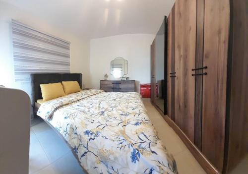 Holiday apartment in zahle with a Panoramic View في زحلة: غرفة نوم بسرير كبير وخزانة خشبية