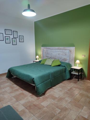 a bedroom with a large green bed with two tables at Casa vacanza Flora in Grottazzolina